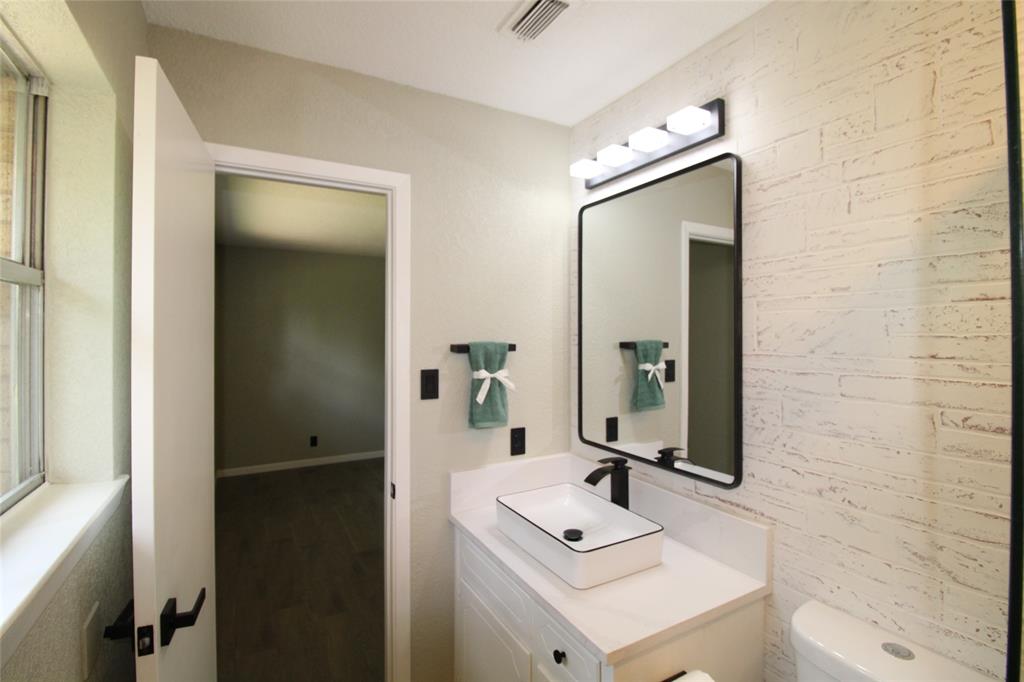 818 East Clinton Avenue Athens, TX 75751 - Photo 19 of 24 a bathroom with a sink mirror and a shower