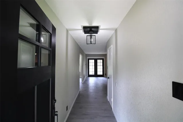 a view of a hallway to a house with wooden floor