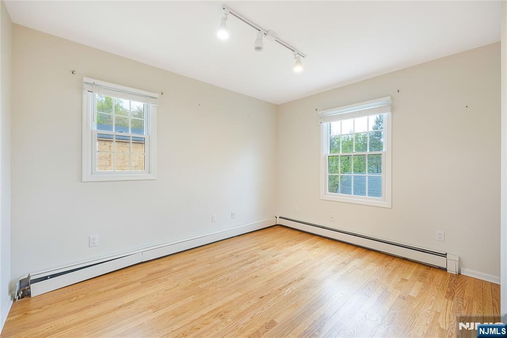 75 Columbus Drive Tenafly, NJ 07670 - Photo 19 of 26 an empty room with wooden floor and windows