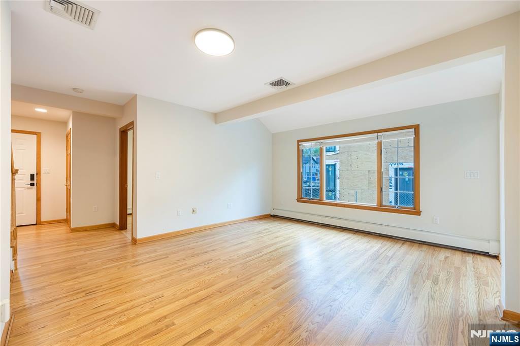 75 Columbus Drive Tenafly, NJ 07670 - Photo 4 of 26 a view of an empty room with wooden floor and a window