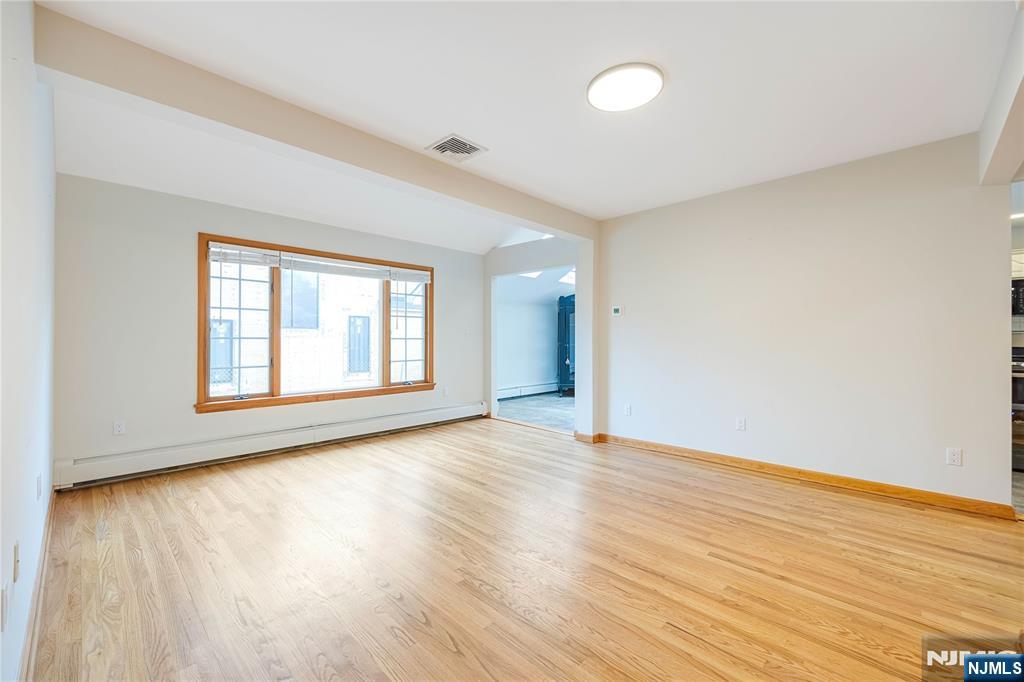 75 Columbus Drive Tenafly, NJ 07670 - Photo 5 of 26 a view of an empty room with wooden floor and a window