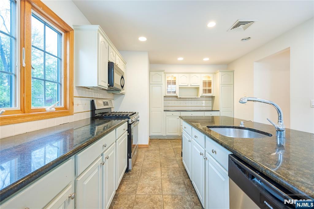 75 Columbus Drive Tenafly, NJ 07670 - Photo 7 of 26 a large kitchen with granite countertop a sink and a stove