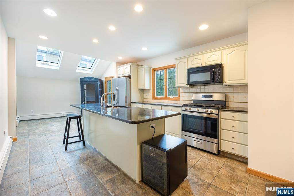 75 Columbus Drive Tenafly, NJ 07670 - Photo 8 of 26 a kitchen with stainless steel appliances a stove a sink and a microwave