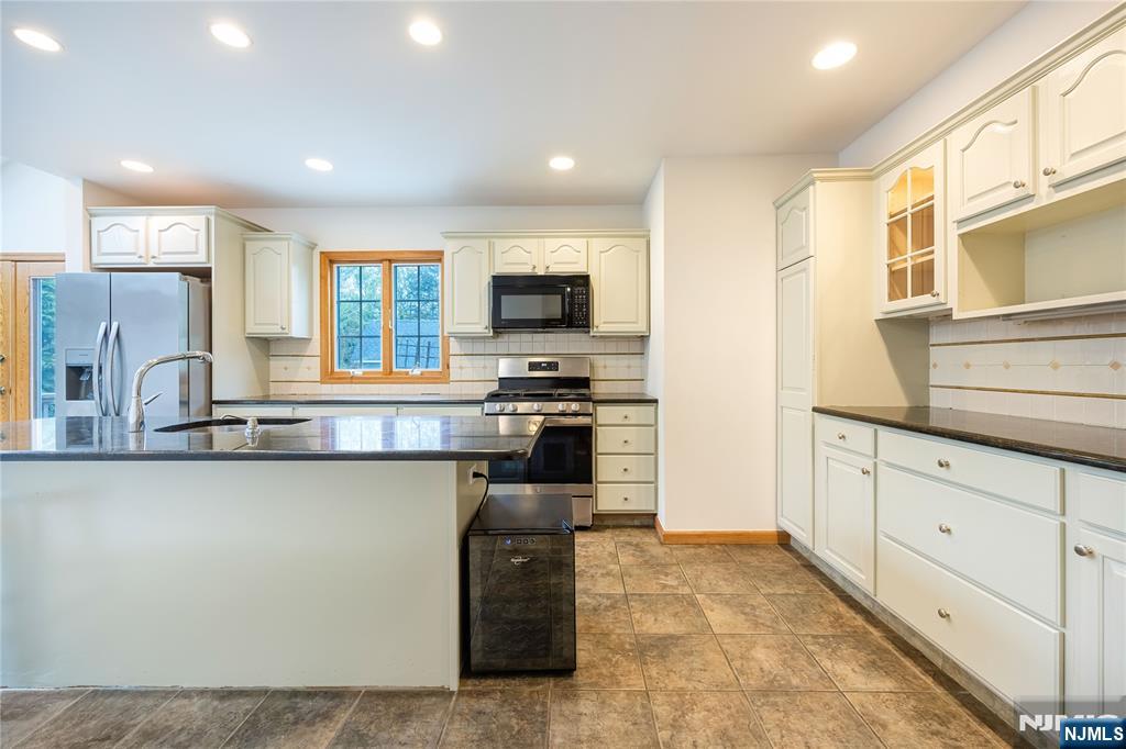 75 Columbus Drive Tenafly, NJ 07670 - Photo 9 of 26 a kitchen with stainless steel appliances granite countertop a stove and a sink