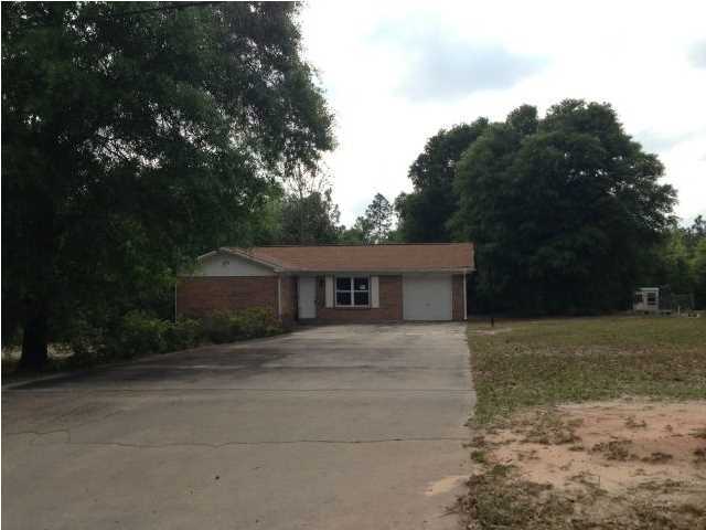 6018 Sand Hill Road Crestview, FL 32539 - Photo 1 of 11 a front view of a house with a yard and trees