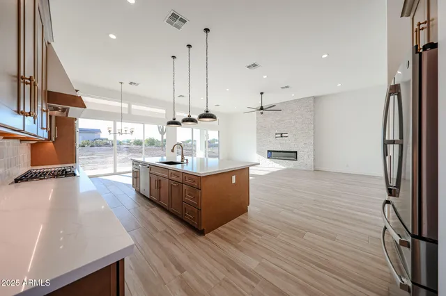 a large kitchen with stainless steel appliances kitchen island a large counter top and a wooden floors