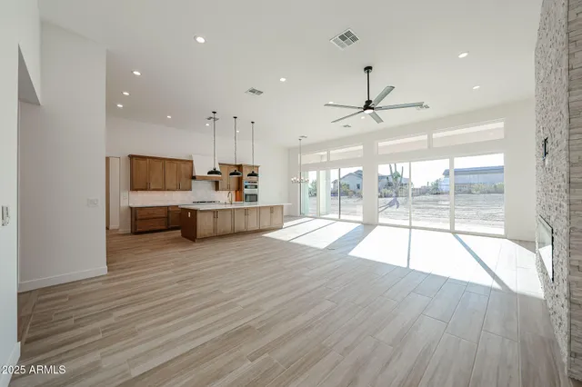 a living room with hard wood floors and a kitchen
