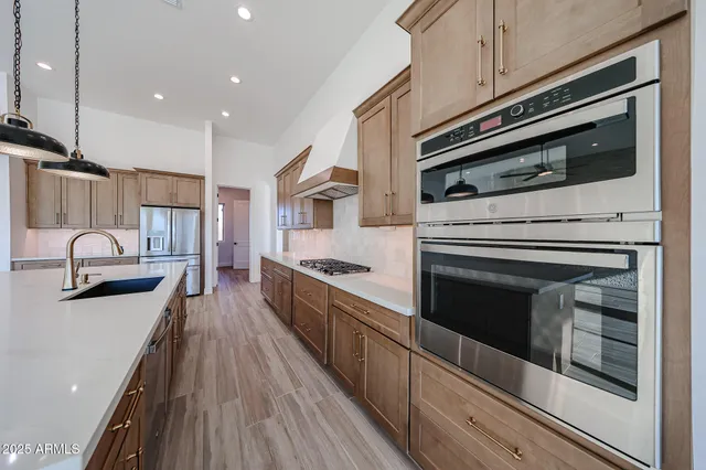 a kitchen with stainless steel appliances kitchen island wooden cabinets granite counter tops and a stove