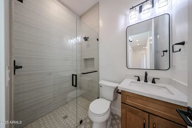 a view of a hallway with wooden floor and a bathroom