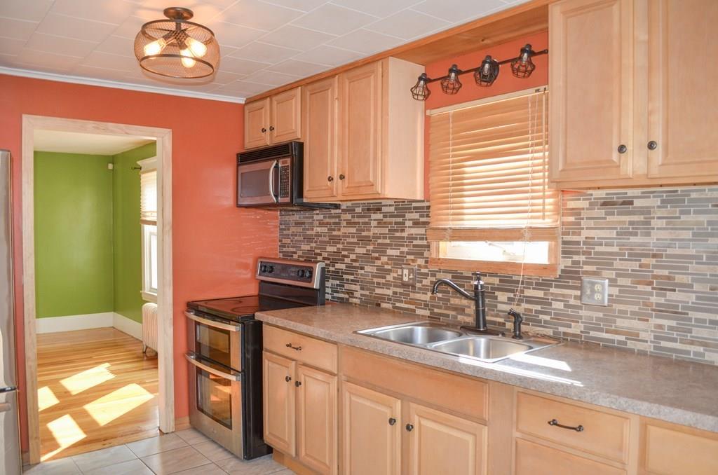 184 Denver Street Springfield, MA 01109 - Photo 3 of 25 a kitchen with stainless steel appliances a sink a stove and a window