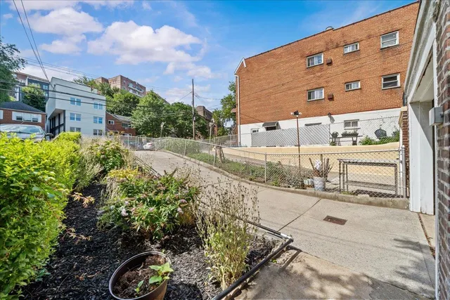 a view of a house with a small yard and potted plants