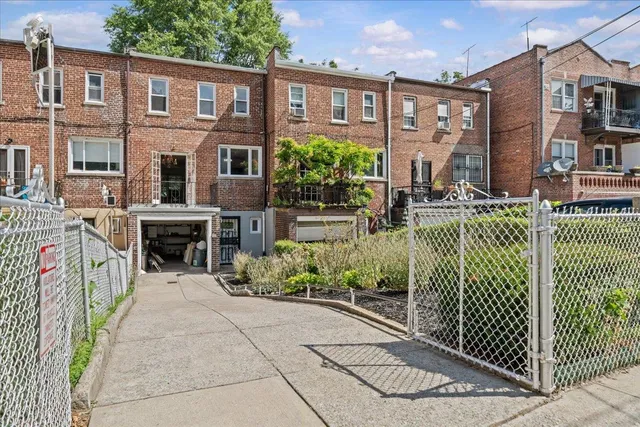 a view of an empty room with chandelier fan and wooden floor