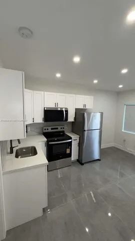 a kitchen with stainless steel appliances a stove a sink and a refrigerator