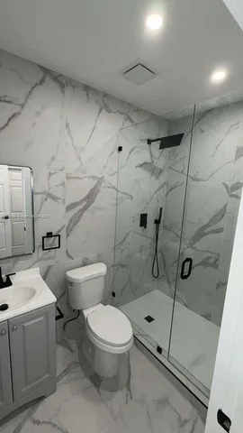 a bathroom with a toilet sink and shower