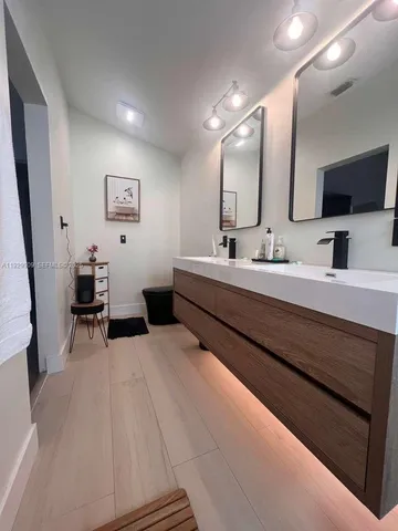 a en suite bathroom with double vanity and a mirror