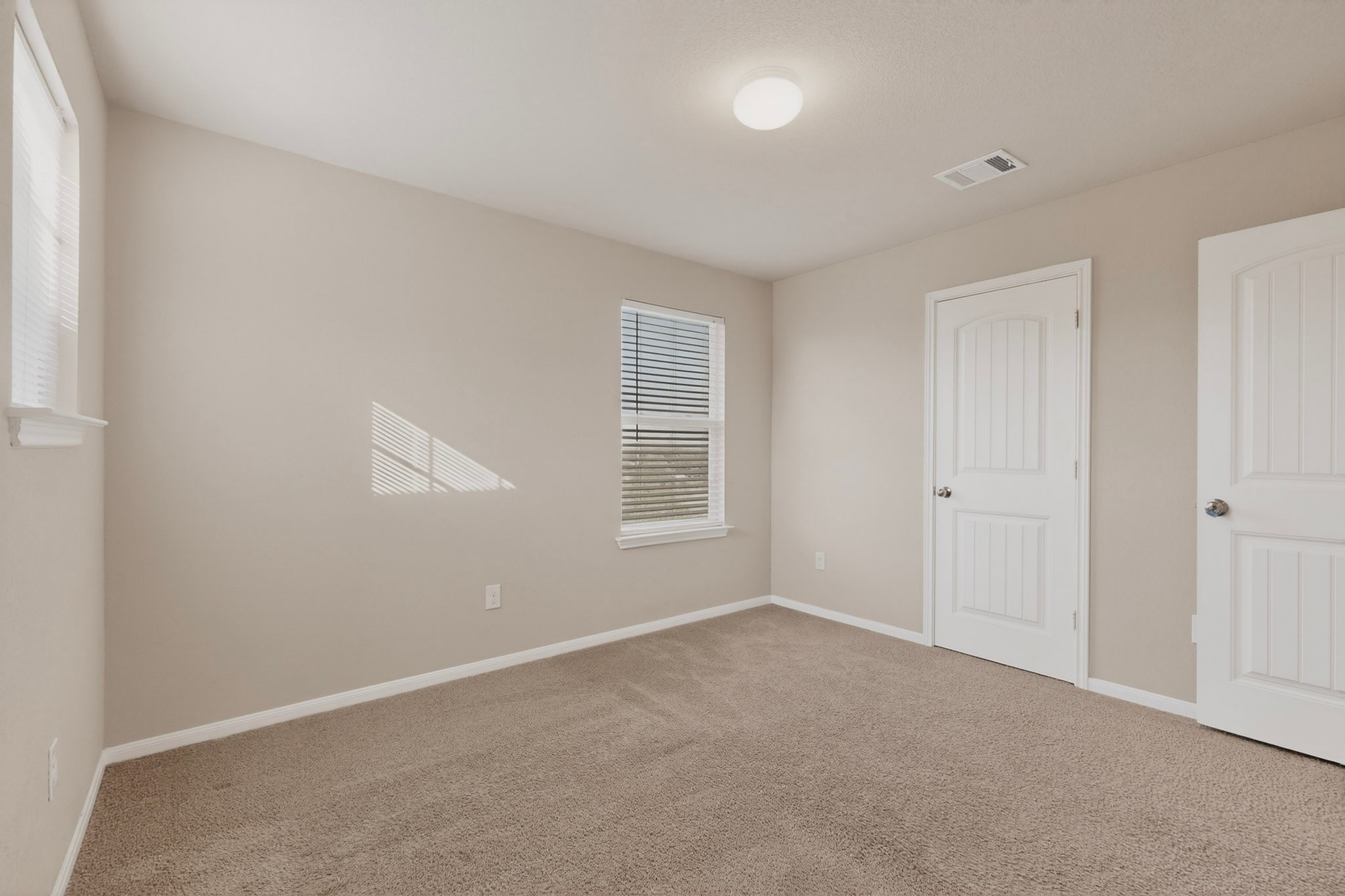 5905 Diamondleaf Bend Austin, TX 78724 - Photo 26 of 38 Carpeted interior room with neutral-toned walls, white baseboards, and two windows featuring blinds