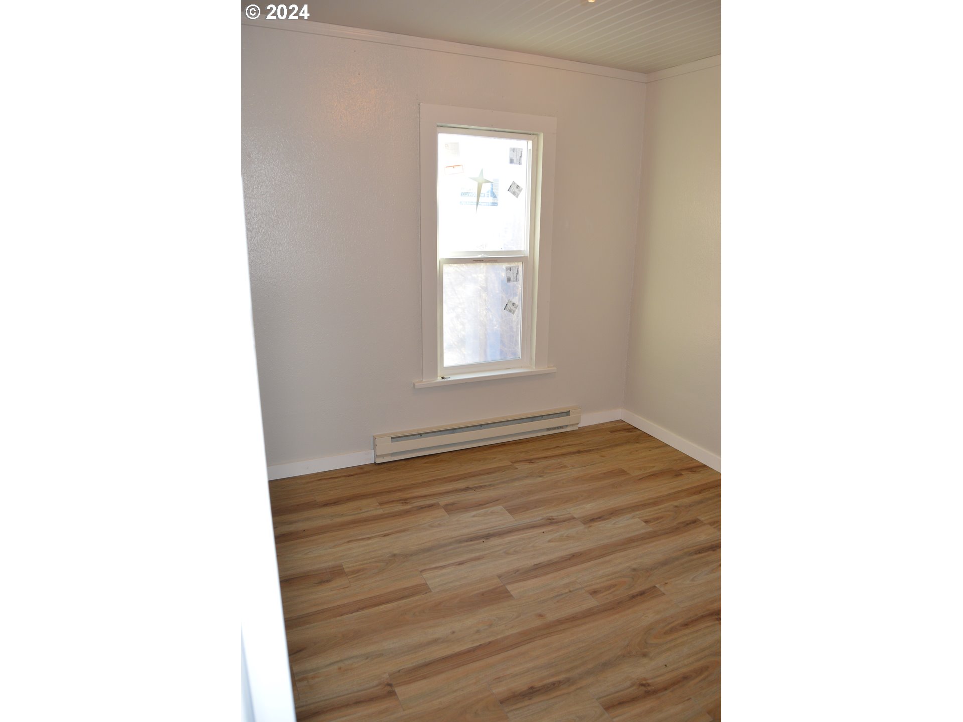 705 Couch Avenue Wallowa, OR 97885 - Photo 21 of 35 a view of an empty room with wooden floor and a window