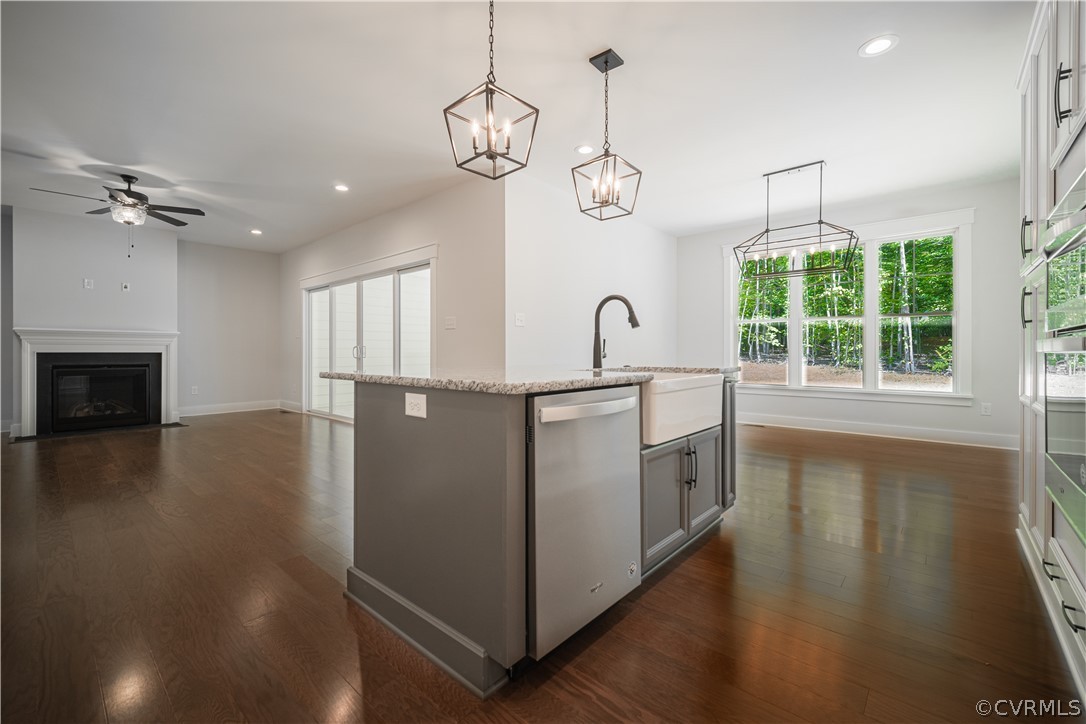 3641 East Rocketts Ridge Road Sandy Hook, VA 23153 - Photo 8 of 17 a kitchen with stainless steel appliances granite countertop a stove a sink dishwasher a refrigerator and a fireplace with wooden floor