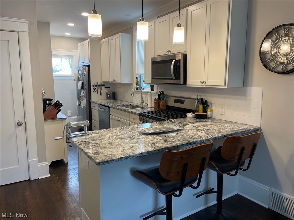 3294 East Overlook Road Cleveland Heights, OH 44118 - Photo 6 of 13 Kitchen with tasteful backsplash, white cabinetry, and stainless steel appliances
