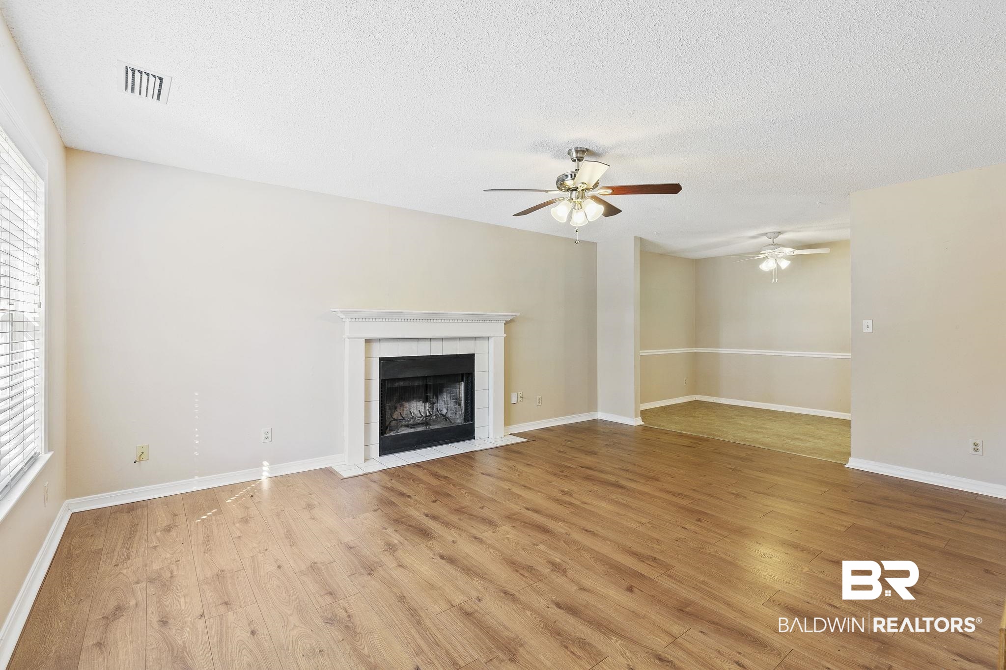 359 Ridgewood Drive Daphne, AL 36526 - Photo 12 of 73 Living room with wood burning fireplace, LVP flooring and ceiling fan.