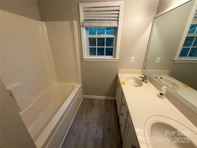 a bathroom with a sink a granite tub and shower