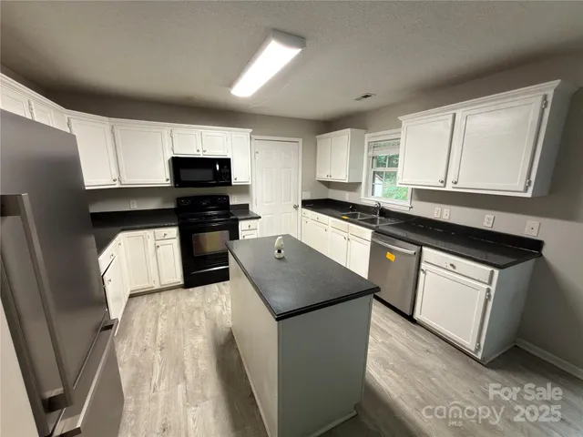 a kitchen with stainless steel appliances granite countertop a stove a sink dishwasher and a refrigerator
