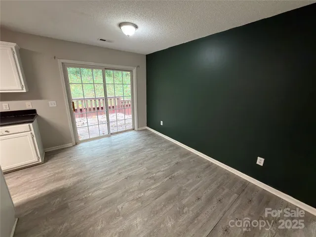 a kitchen with granite countertop a refrigerator a sink a stove top oven a counter space and cabinets