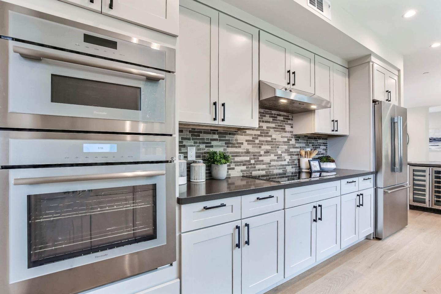 269 Willow Road Menlo Park, CA 94025 - Photo 7 of 26 a kitchen with stainless steel appliances white cabinets and a stove a oven with granite countertops