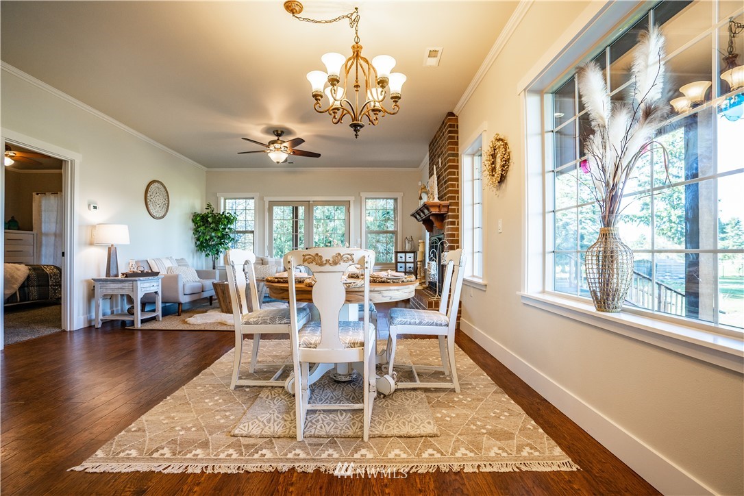 3116 Jackson Highway Chehalis, WA 98532 - Photo 14 of 40 a dining room with wooden floor a chandelier a wooden table and chairs