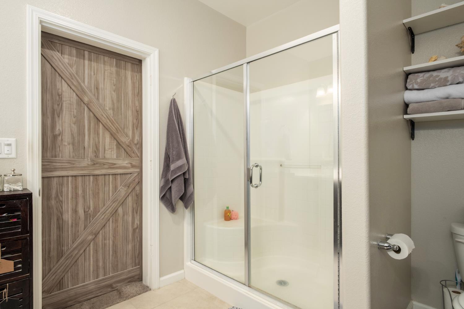 153 Drake Street Madera, CA 93638 - Photo 15 of 34 a bathroom with a shower and a glass door