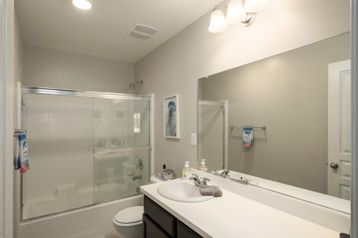 153 Drake Street Madera, CA 93638 - Photo 27 of 34 a bathroom with a bathtub shower sink vanity and toilet