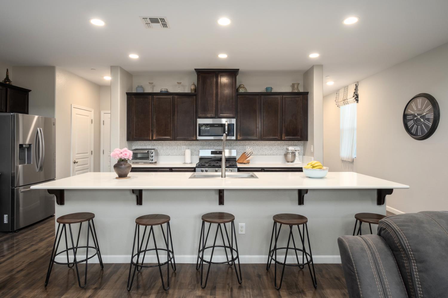 153 Drake Street Madera, CA 93638 - Photo 9 of 34 a kitchen with a table chairs refrigerator and microwave