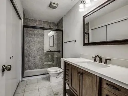 a bathroom with a sink a toilet and shower