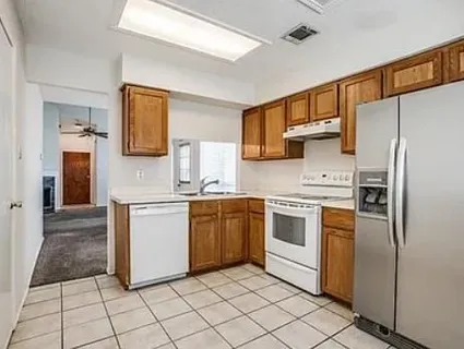 a kitchen with stainless steel appliances granite countertop a refrigerator sink and stove