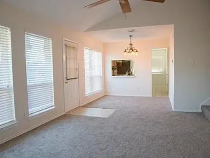 an empty room with windows and cabinet