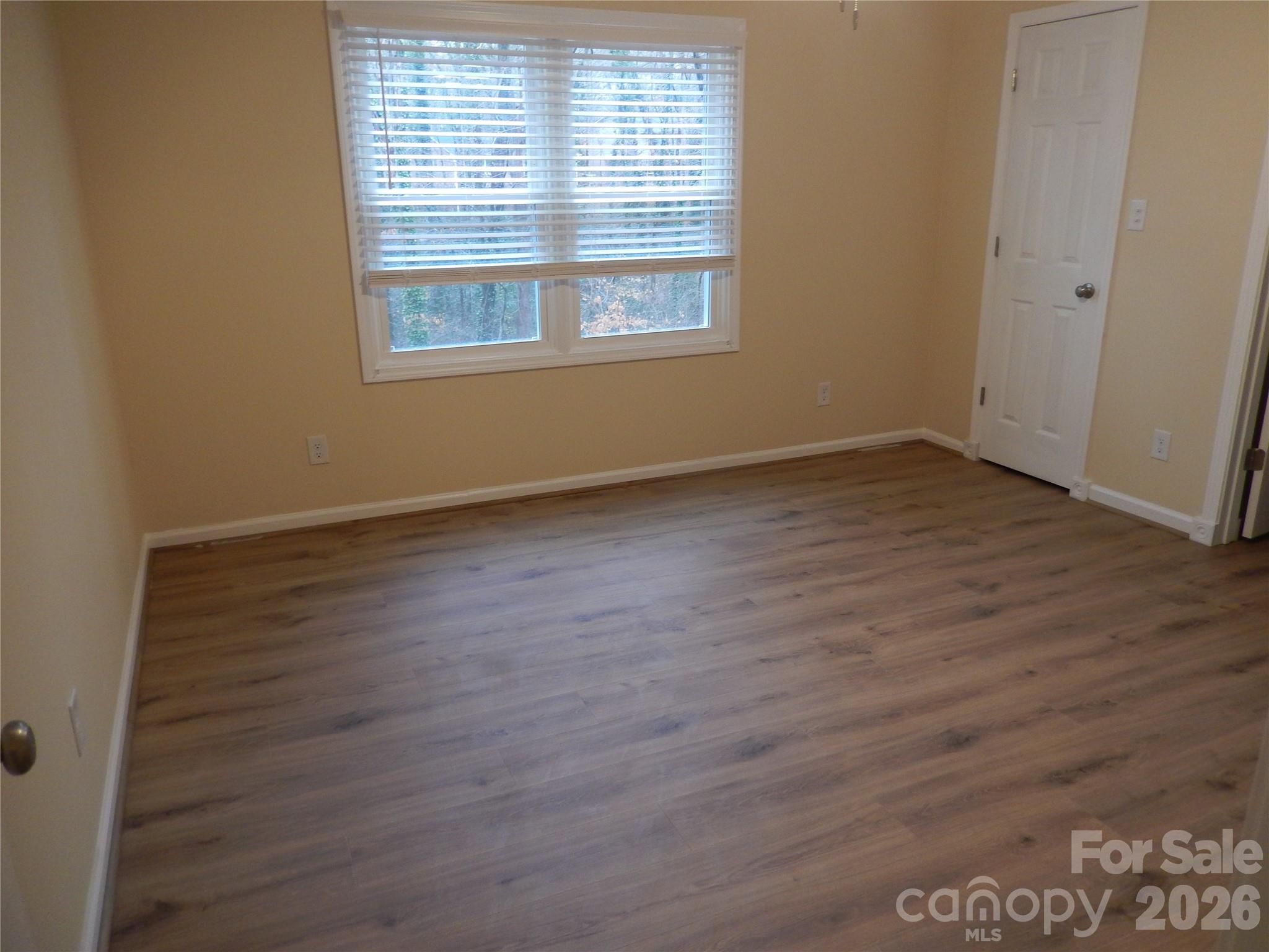 547 Brent Road Raleigh, NC 27606 - Photo 11 of 15 an empty room with wooden floor and windows