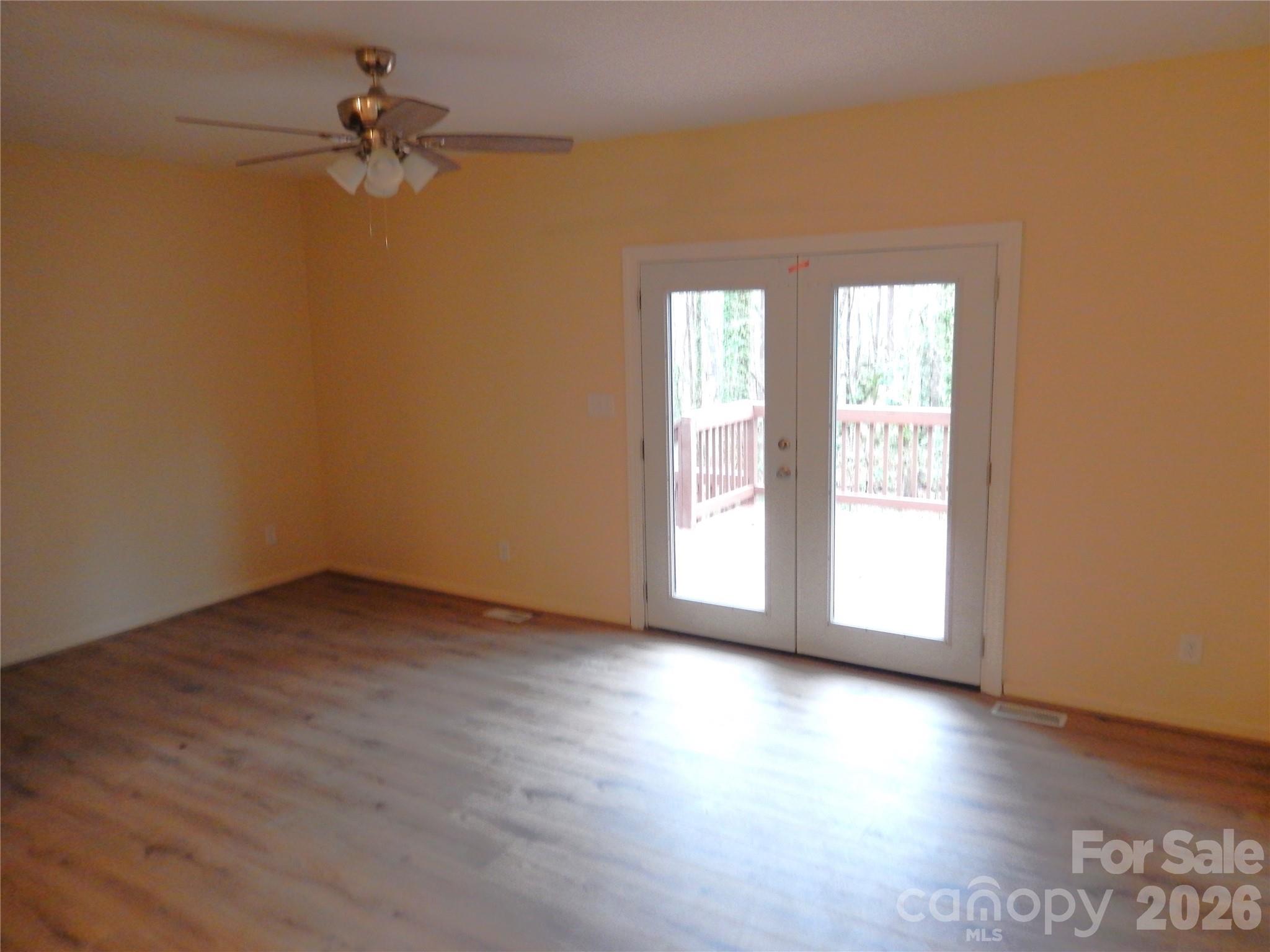 547 Brent Road Raleigh, NC 27606 - Photo 2 of 15 an empty room with wooden floor fan and windows