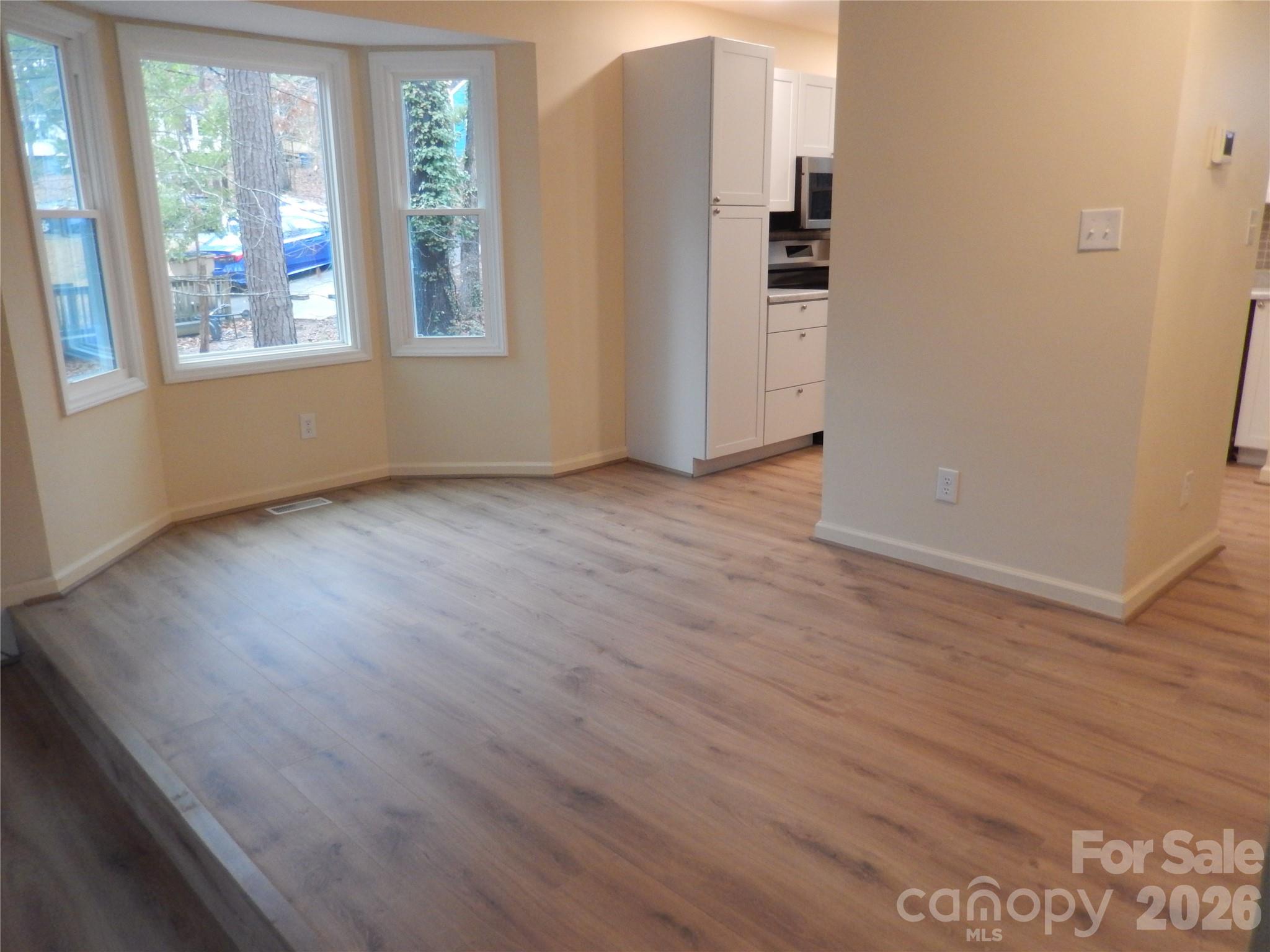 547 Brent Road Raleigh, NC 27606 - Photo 3 of 15 an empty room with wooden floor and windows