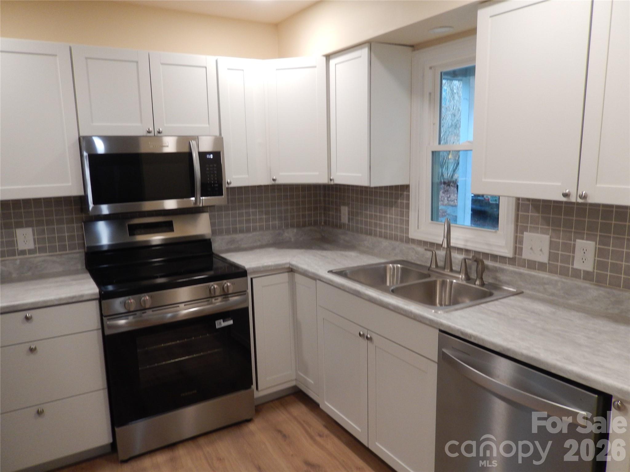 547 Brent Road Raleigh, NC 27606 - Photo 4 of 15 a kitchen with a sink and a stove top oven with wooden floor