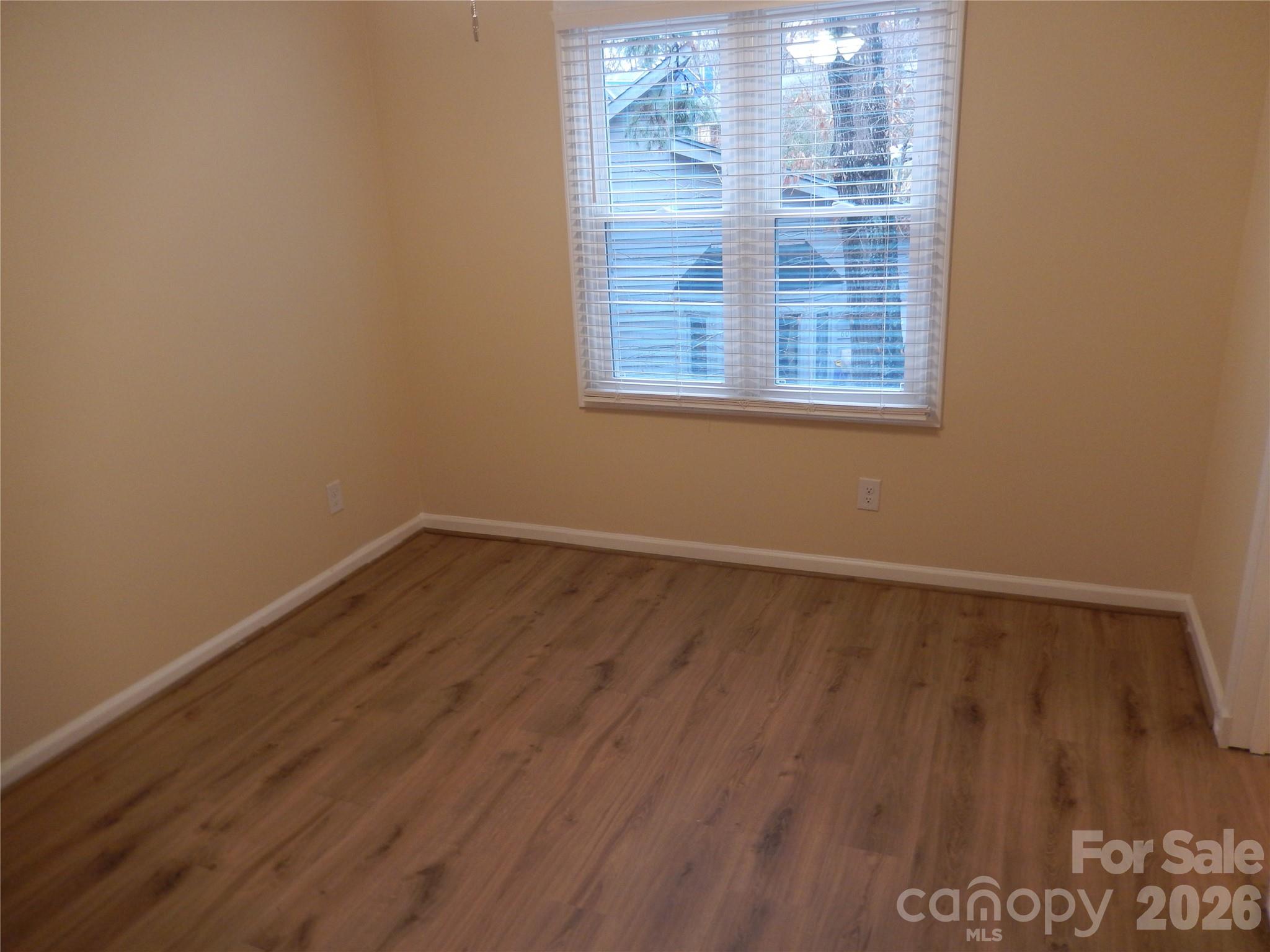 547 Brent Road Raleigh, NC 27606 - Photo 10 of 15 a view of an empty room with wooden floor and a window