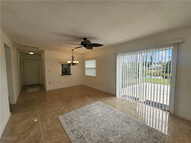 en empty room with windows and ceiling fan