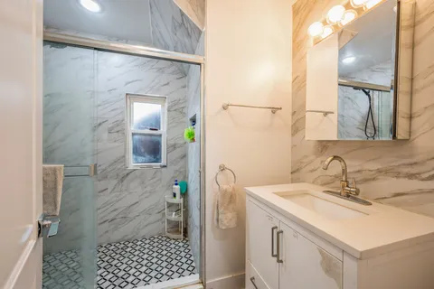 a bathroom with a sink a toilet and shower