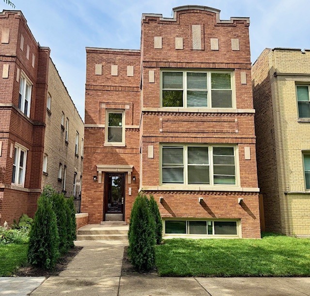 a view of a brick building next to a yard