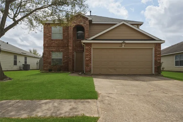 a front view of a house with a garden and garage
