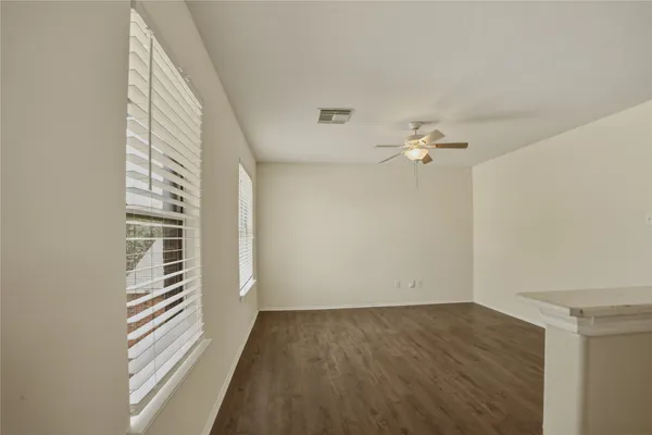 a view of a hallway with wooden floor and a window