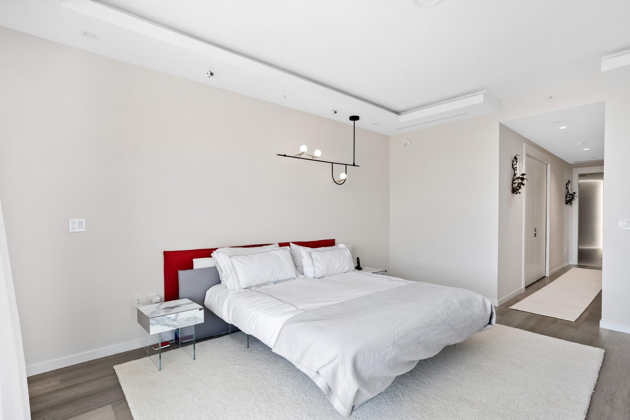 200 Southeast Mizner Boulevard, Unit 717 Boca Raton, FL 33432 - Photo 19 of 66 a bedroom with a bed and wooden floor