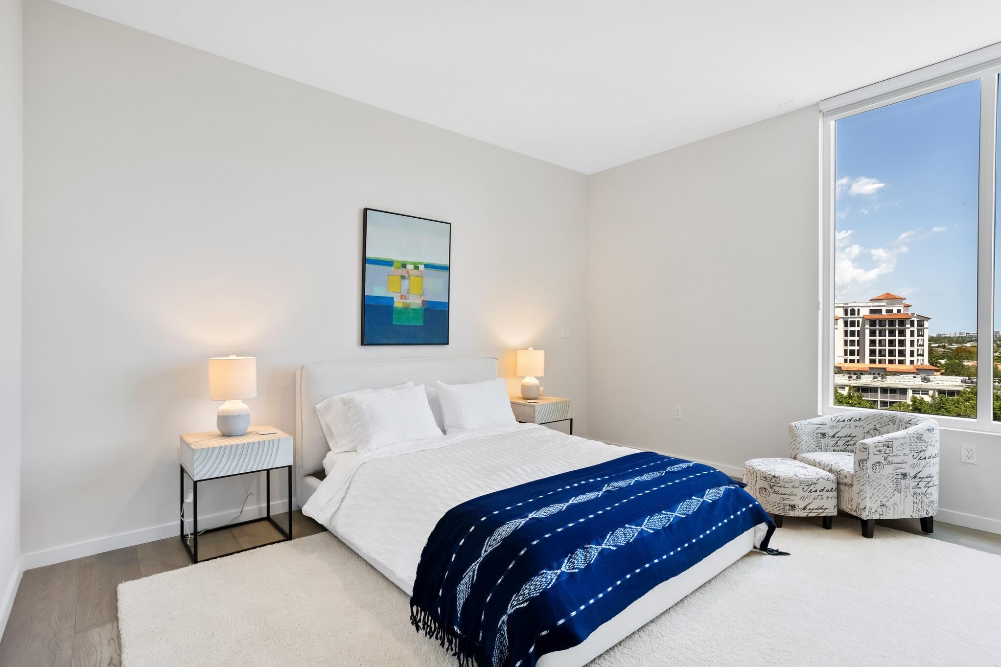 200 Southeast Mizner Boulevard, Unit 717 Boca Raton, FL 33432 - Photo 26 of 66 a bedroom with a bed and a lamp