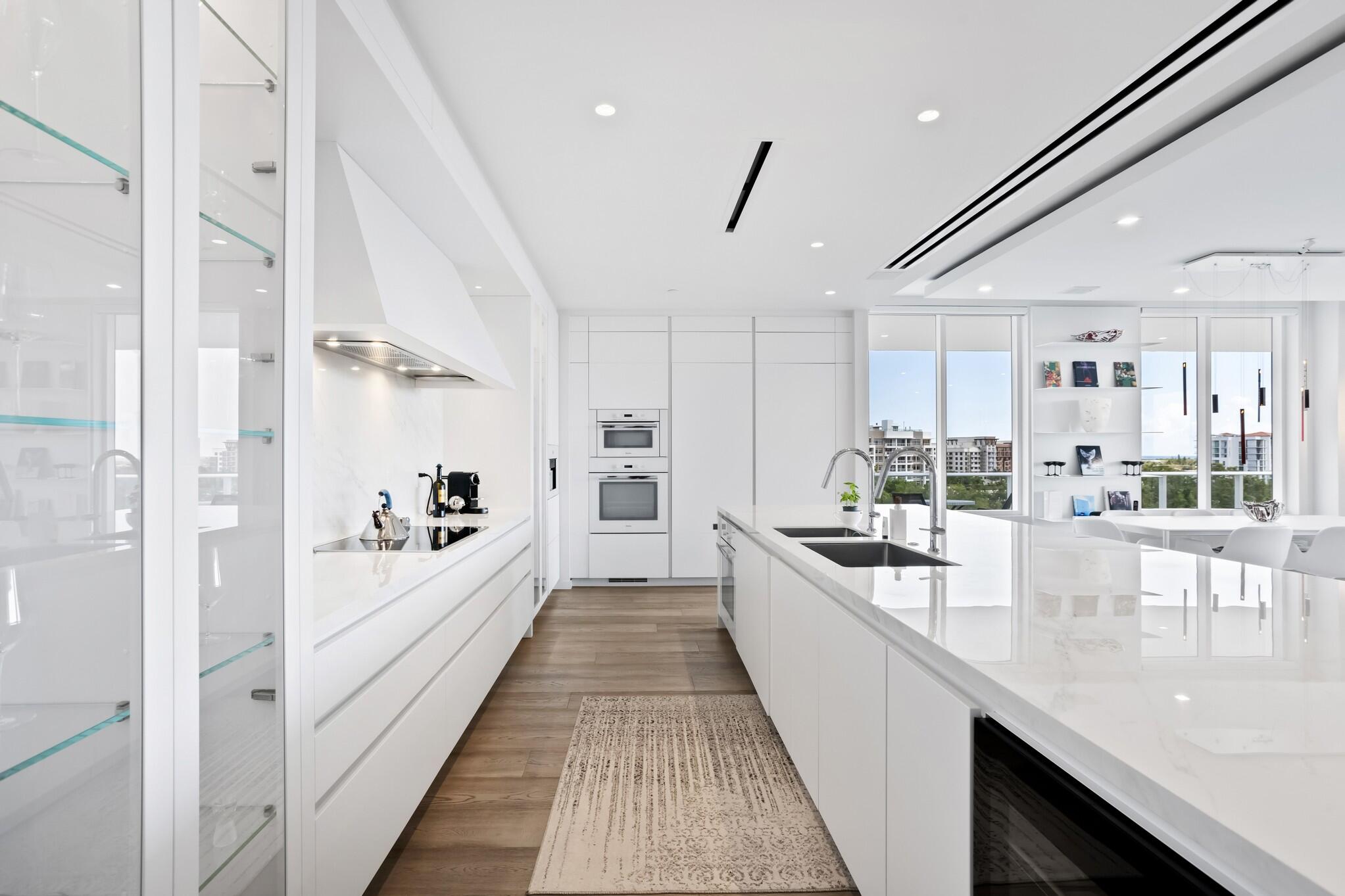 200 Southeast Mizner Boulevard, Unit 717 Boca Raton, FL 33432 - Photo 10 of 66 a large white kitchen with stainless steel appliances