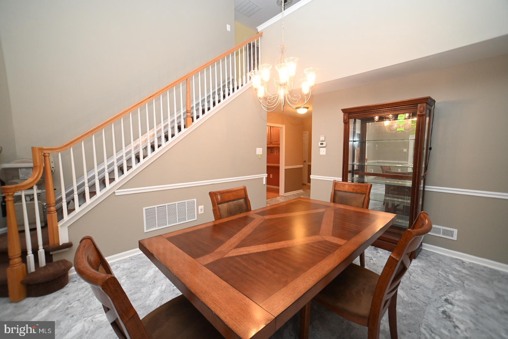 29 Ashley Drive Warminster, PA 18974 - Photo 10 of 44 a view of dining room and livingroom with furniture wooden floor a rug a fireplace and a chandelier