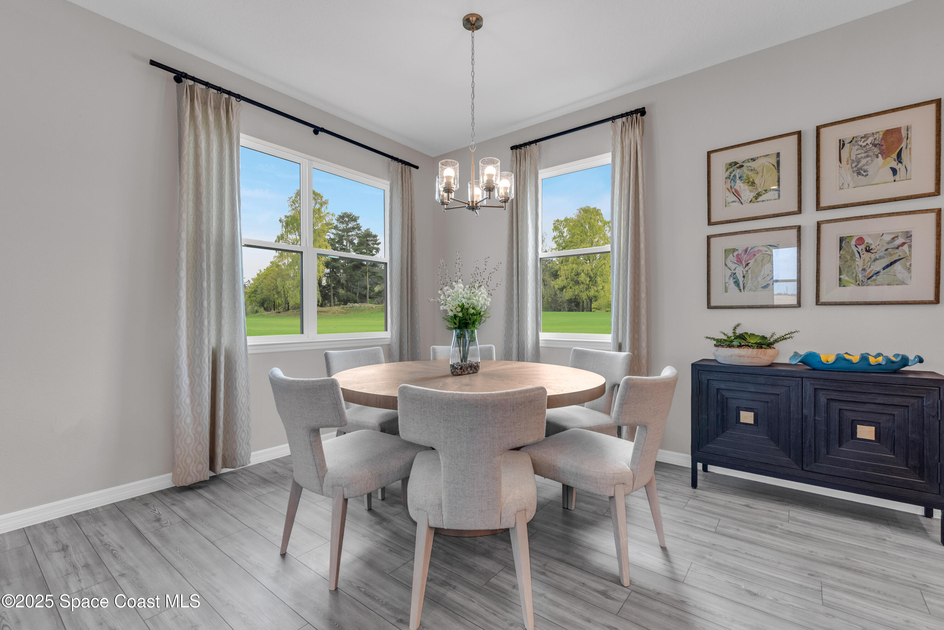 615 Poller Way Cocoa, FL 32927 - Photo 11 of 29 a dining room with wooden floor a chandelier a wooden table and chairs